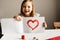 Girl holding paint red heart card for valentines day, crafting, love