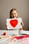 Girl holding paint red heart card for valentines day, crafting, love