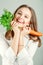 Girl holding parsley and carrots