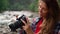 Girl holding photo camera in hands. Photographer looking pictures on camera