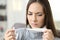 Girl holding a pill and checking thermometer temperature