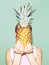 Girl holding pineapple.