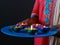 A girl holding a plate of Colourful lit diyas