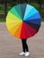 A girl holding a Rainbow coloured umbrella