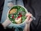 Girl holding salad with spinach, pear, pomegranate, cheese