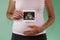 The girl is holding a snapshot of an ultrasound twin in the fourth week of pregnancy. First trimester. Confirmation of pregnancy.