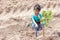 A girl is holding a spade to plant trees to help reduce global warming.