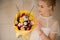 Girl holding a spring bouquet of different flowers decorated with willow branches, little chiken toy wrapped in yellow