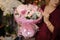 Girl holding a spring bouquet of tender rosy color roses in the wrapping paper