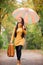 Girl holding suitcase and umbrella