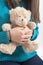 Girl holding teddybear, closeup on white