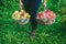 Girl holding two large baskets of apples