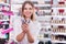 Girl holding various eyeliners in beauty store