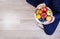 Girl holding white plate with apples, plums, kiwi and pomegranate.