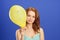 Girl holding yellow smiling balloon