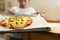 The girl holds on a baking sheet prepared for baking pizza with beef. Cooking.