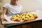 The girl holds on a baking sheet prepared for baking pizza with beef. Cooking.