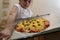 The girl holds on a baking sheet prepared for baking pizza with beef. Cooking.