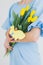 Girl holds a bouquet of tulips and Easter ginger cookies