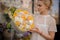 Girl holds bouquet of white and yellow flowers