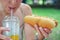 Girl holds a classic hotdog with ketchup and fried onions in her hand.