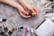 Girl holds gel polish on a gray concrete texture background, top view.Nail care and nail care