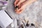 Girl holds gel polish on a gray concrete texture background, top view.Nail care and nail care