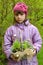 The girl holds in hand a basket with daisy seedling