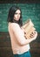 Girl holds heavy pile of old books, chalkboard background. Diligent student preparing for exam test. Profound research