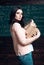 Girl holds heavy pile of old books, chalkboard background. Girl student works on scientific research. Diligent student
