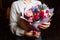 The girl holds in her hand a magnificent bouquet with multi-colored flowers