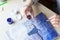 Girl holds in her hands a brush and a cover from a watercolor jar the background of a drawing of a cat, the night sky and the moon