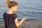 Girl holds a little compass indicating the direction on the background of the sea