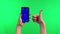 The girl holds a phone with a blue screen on the chromakey and gives a thumb up. A woman`s hand with a red manicure