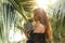 Girl holds pineapple in hands on the background of the pool in the tropics