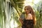 Girl holds pineapple in hands on the background of the pool in the tropics