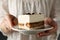 Girl holds plate with delicious tiramisu close up. Selective focus