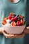 A girl holds a plate of fruits and yogurt, promoting a healthy and nutritious choice. balanced lifestyle