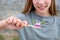 The girl holds a toothbrush with herbed toothpaste with rosemary in her hand. Selective focus on toothbrush and rosemary