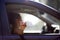 Girl holds trash outside the car window. A woman is about to throw waste out of a car. Environmental pollution