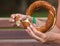 A girl holds a Turkish bagel simit in her hand and breaks it, close-up