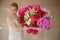 Girl holds very big bouquet with tulips, irises and roses
