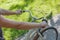 The girl holds the wheel of a beige bike