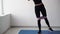 a girl at home using elastic rubber trains the muscles of the lower body, a determined athlete who achieves fitness