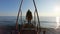 The girl in hood with backpack walks along the metal pier to the sea