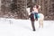 Girl, horse trainer and white horse in a winter