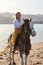 Girl horseback rider sitting on a horse stroking horse`s neck