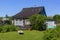 Girl on hot summer day sunbathes on a cottage lawn on cot in village