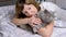 Girl Hugging a Gray Fluffy British Cat While Lying on a Soft Bed in the Room