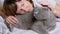 Girl Hugging a Gray Fluffy British Cat While Lying on a Soft Bed in the Room